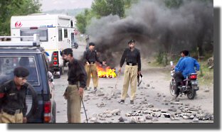 OJ drives passed a burning tyre outside Gilgit.